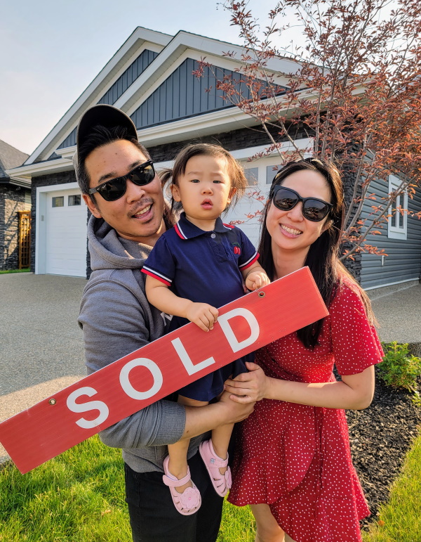 Family in front of their newly sold home
